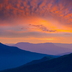 mountain slope silhouette on dramatic sunset background