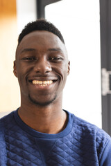 Obraz premium Portrait of happy african american man with short black hair smiling at home
