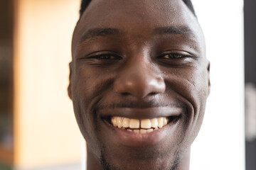 Portrait of happy african american man with short black hair smiling at home