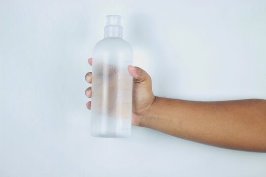 Male hand holding a bottle of water, isolated on a white background. Closed. High resolution product