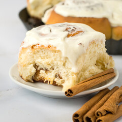 Fresh Cinnabon rolls with cinnamon and white cheese cream, close up.