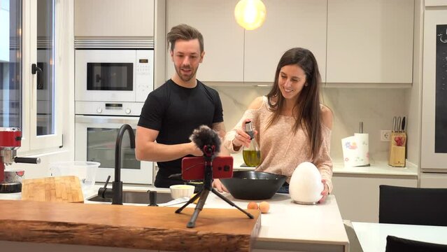 Couple food vlogger making video while prepping vegetables in kitchen