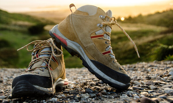 Hiking boots stand in the foreground of a Scandinavian sunset in Mols Bjerge Denmark