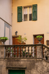 Image of a detail with old medieval architecture italian neighborhood and windows with wooden shutters .