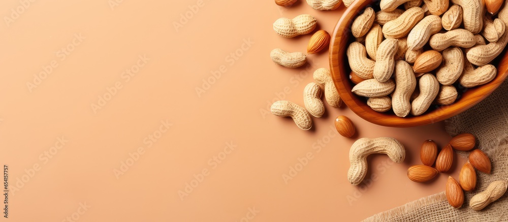 Poster peanuts in a brown bowl on a isolated pastel background copy space used for making oil and peanut bu
