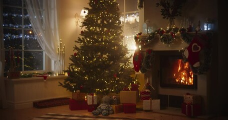 Peaceful Snowy Christmas Evening: Empty Shot of Decorated Corner in Modern House with Christmas Tree, Fireplace and Gifts. Home of a Family Celebrating the Holidays. Slow Motion Static - Powered by Adobe
