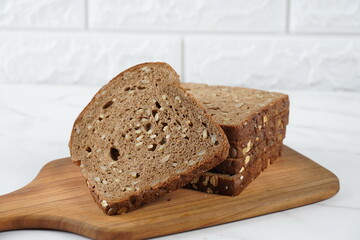 Sliced rye bread on cutting board. Whole grain rye bread with seeds