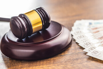 Judge gavel and british pound sterling on wooden table.
