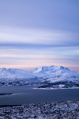 Evening view from the top of the mountain in Tromso, Norway. Polar circle, in winter. Fjord, polar sea. Dark evening. Breath-taking view. Town, city from the top, drone view, on island. Polar night