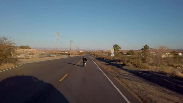 Experience the the open road in this cinematic clip captures as a lone adventurer rides past enchanting old farms in the heart of the desert, riding a vintage chopper motorcycle.