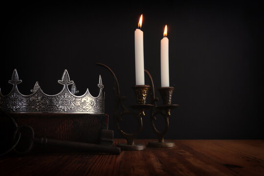 low key image of beautiful queen or king crown over antique book. vintage filtered. fantasy medieval period