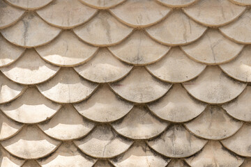 Close-up shot of a wall designed to resemble fish scales. Concrete texture mimicking the scales of...