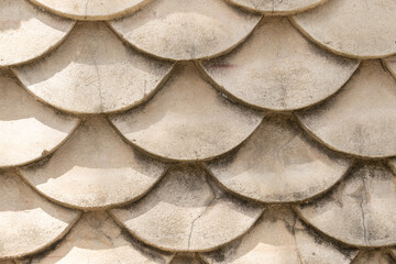 Close-up concrete wall designed resemble fish scales, reminiscent of Japanese koi fish artwork,...