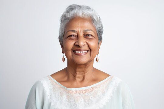 Portrait Showcases Delightful Elderly Asian Indian Woman, Radiating Warm Smile, Ideal For Use In Web Or Print Advertisements, Set Against White Wall Backdrop