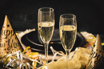 Two glasses of sparkling wine, New Year party with golden decoration