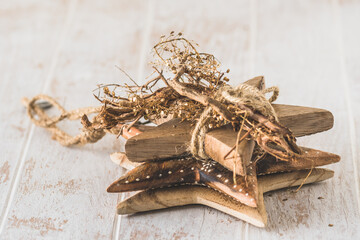 Three deco wooden stars stacked on white wooden table
