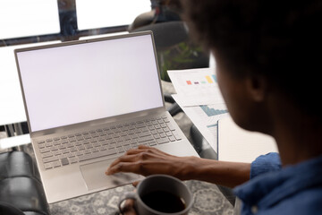 African american casual businessman sitting at table using laptop with copy space on screen