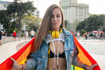 Young woman with lgtbi flag fighting and showing strength out of pride. Concept: lifestyle, pride, outdoors