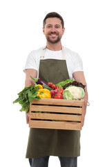 Harvesting season. Happy farmer holding wooden crate with vegetables on white background