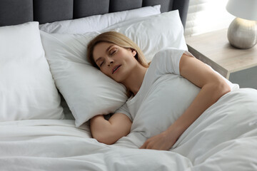 Woman snoring while sleeping in bed at home