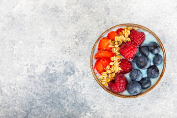 Granola bowl. Yogurt with oatmeal, fresh berries, spirulina and chia seeds. Healthly food. Tasty breakfast. Yogurt with strawberries, raspberries, blueberries, peaches, mint and mendal. Copy space.