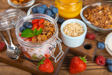 Granola bowl. Yogurt with oatmeal, fresh berries, spirulina and chia seeds. Healthly food. Tasty breakfast. Yogurt with strawberries, raspberries, blueberries, peaches, mint and mendal. Copy space.