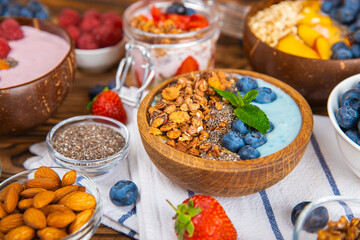 Granola bowl. Yogurt with oatmeal, fresh berries, spirulina and chia seeds. Healthly food. Tasty breakfast. Yogurt with strawberries, raspberries, blueberries, peaches, mint and mendal. Copy space.