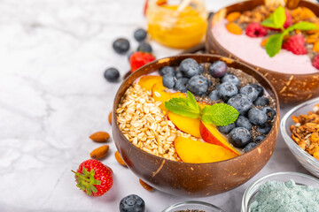 Granola bowl. Yogurt with oatmeal, fresh berries, spirulina and chia seeds. Healthly food. Tasty breakfast. Yogurt with strawberries, raspberries, blueberries, peaches, mint and mendal. Copy space.