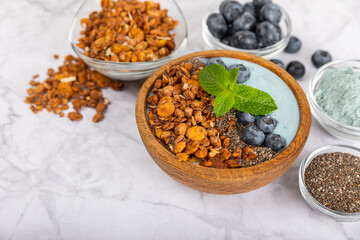 Granola bowl. Yogurt with oatmeal, fresh berries, spirulina and chia seeds. Healthly food. Tasty breakfast. Yogurt with strawberries, raspberries, blueberries, peaches, mint and mendal. Copy space.