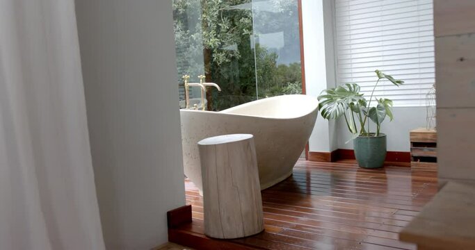 General view of bathroom with bathtub and window, slow motion