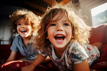 Poster Retrato de dos niños felices y sonrriendo se divierten en el interior de casa. retrato familiar. © TaniaC.
