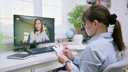 Psychologist in online therapy meeting with young female patient