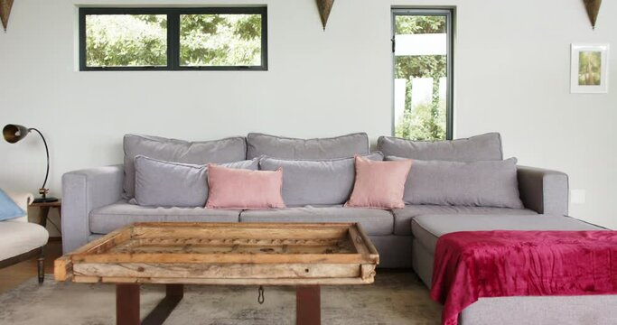 General view of a living room with sofa and coffee table, slow motion