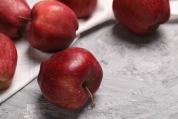 Fresh red apples on grey textured table, closeup. Space for text
