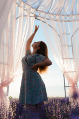 A young woman is dancing in a lavender field at sunrise