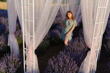A young woman in a lavender field at sunrise
