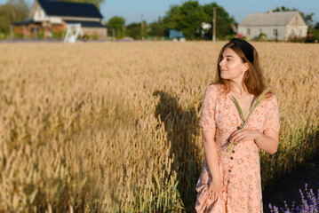A woman in a beautiful dress in a rye field in the morning