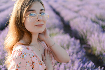 A young woman with glasses in the morning in a lavender field