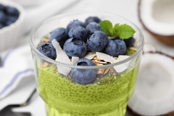 Tasty matcha chia pudding with coconut and blueberries in glass, closeup. Healthy breakfast