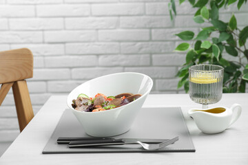 Delicious salad with beef tongue and vegetables served on white wooden table indoors. Space for text