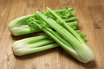 Bunches of fresh green celery on wooden table