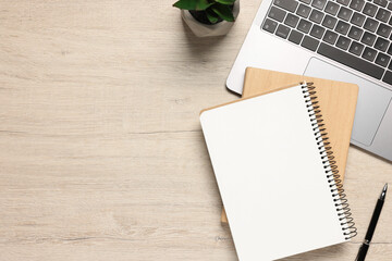 Flat lay composition with laptop and different stationery on light wooden desk, space for text....