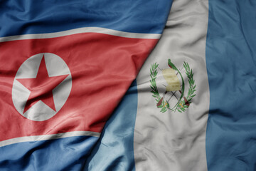 big waving realistic national colorful flag of north korea and national flag of guatemala .