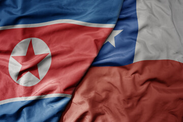 big waving realistic national colorful flag of north korea and national flag of chile .