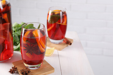 Delicious punch drink and anise stars on white wooden table. Space for text