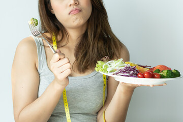Close up view on young woman boring eat salad during diet because not tasty