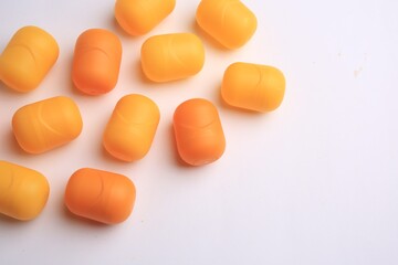 Sveti Vlas, Bulgaria - June 30, , 2023: Orange plastic capsules from Kinder Surprise Eggs on white background, above view and space for text