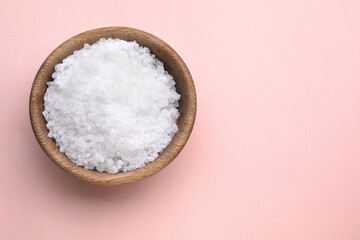 Bowl with sea salt on pale pink background, top view. Space for text