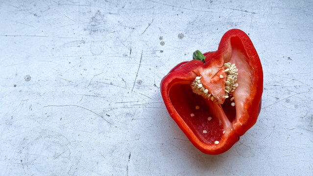 Fresh red ugly pepper and pepper cross sections with seeds isolated on gray background.