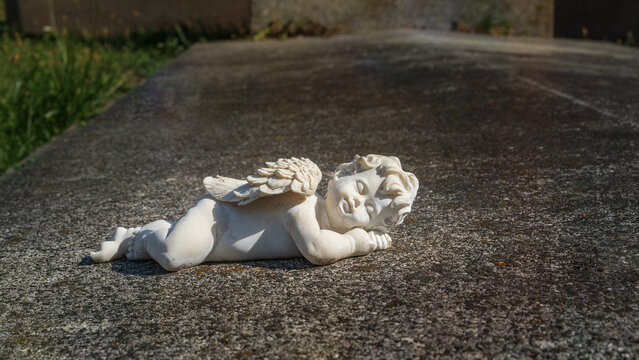 Lying figurine of an angel on the grave. Place for text.